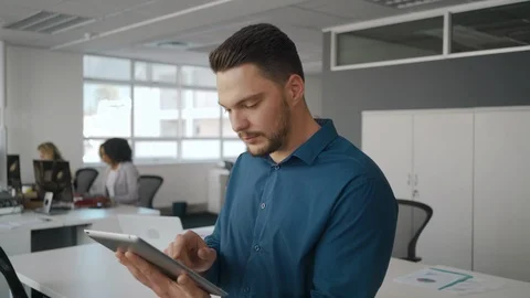 Young smiling businessman using tablet computer looking and smiling at camera Stock Footage 115491651