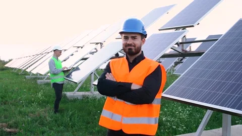 Young smiling engineer looks at the camera near the construction. Video stock 140206091