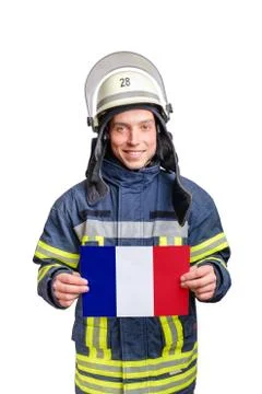 Young smiling firefighter looking to the camera and holding paper sheet with Stock Photos
