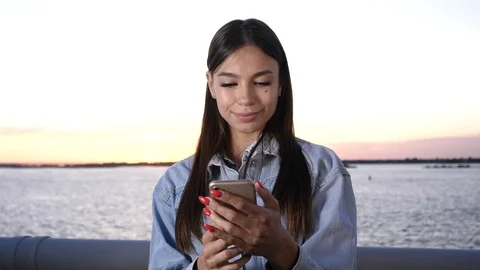 Young Smiling Girl Using Mobile Phone and Smiling. Stock-Footage 115970001