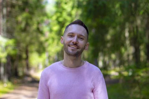 Young smiling guy with a beard on the background of a forest landscape Stock-Fotos