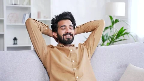 Young smiling handsome bearded man relaxing with his eyes closed and his hands  Stock Footage 252215602
