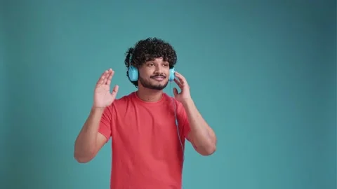 Young smiling happy cheerful student Indian man 20s dancing with headphones Stock Footage 238679341