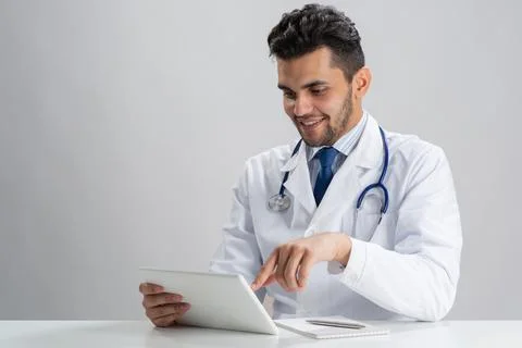 Young smiling internist using tablet computer Stock Photos