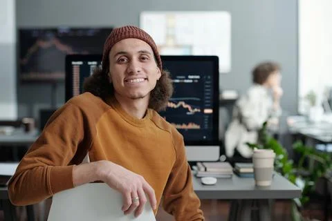 Young smiling IT support manager sitting by workplace in front of camera 写真素材