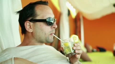Young smiling man drinking exotic cocktail in luxury bar  HD Stock Footage 10888374