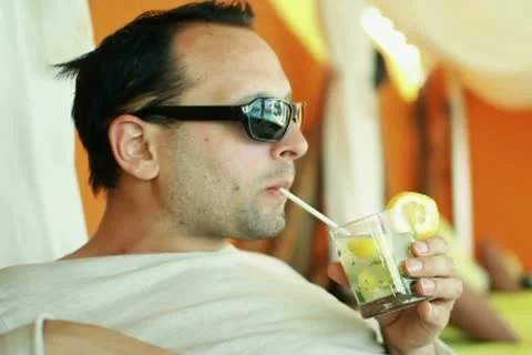 Young smiling man drinking exotic cocktail in luxury bar  NTSC Stock Footage 10888379