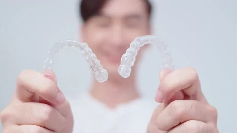 Young smiling man holding invisalign braces over white background studio, den Vídeo Stock 201669673