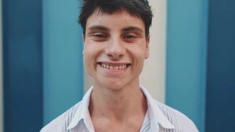 Young smiling man raises his head, opens his eyes and smiles looking at the Stock Footage 250843829