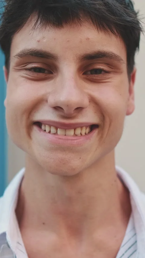 Young smiling man raises his head, opens his eyes and smiles looking at the Stock Footage 252505170