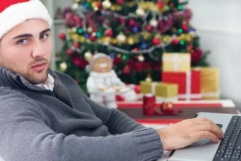 Young smiling man using laptop on christmas eve Stock Photos