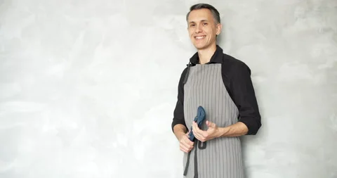 Young smiling man worker or repairman holding a wrench against a gray background Stock Footage 134621314