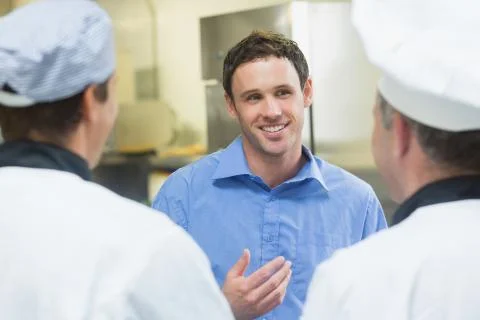Young smiling manager talking to the staff Stock Photos