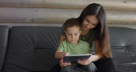 Young smiling mother explaining to her young son how to properly complete a task Stock Footage 197441738