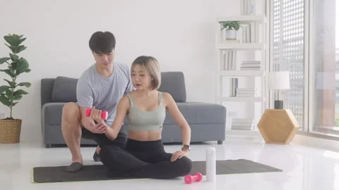 Young smiling multi ethnic couple exercising together at home Stock Footage 248587085