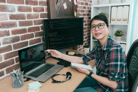Young smiling programmer manager pointing laptop 스톡 사진