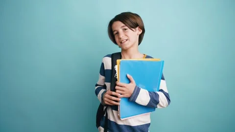 Young smiling student boy holding books and backpack Stock Footage 335275729