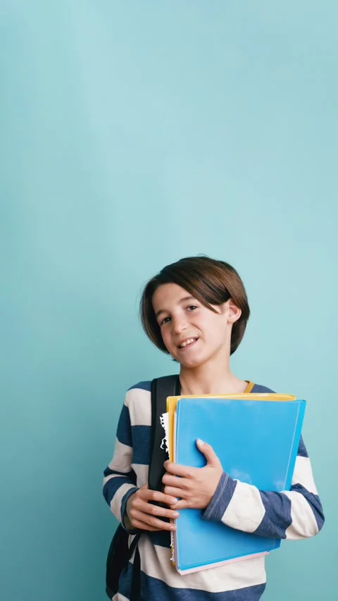 Young smiling student holding folders and backpack. Vertical Stock Footage 333410120