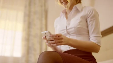 Young smiling woman holding a smartphone and typing on it Stock Footage