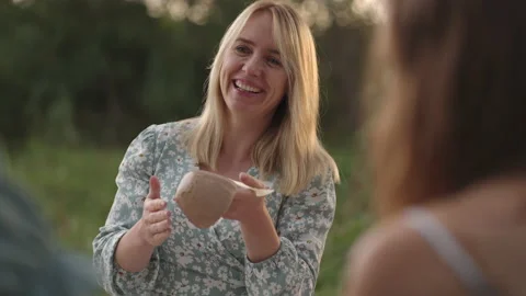 A young smiling woman puts a pattern, a drawing on a clay product with a tool, a Stock Footage 161302829
