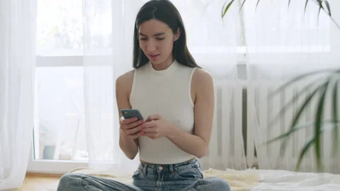 Young Smiling Woman Using Mobile Phone At Home. Stock Footage 220728110
