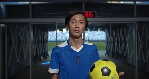 Young soccer player, man talking with phone sitting in the locker room at the Stock Footage 139206581