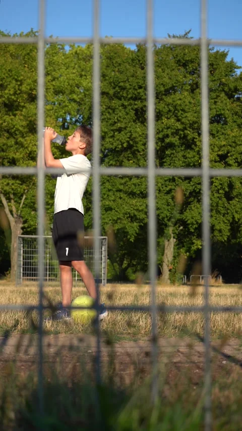 The young soccer player takes a quick water break and then gets back to play Stock Footage 344557963