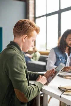 Young software developer scrolling through sketches of new mobile applications Stock Photos