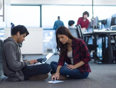 Young software developers couple working on the floor 스톡 사진
