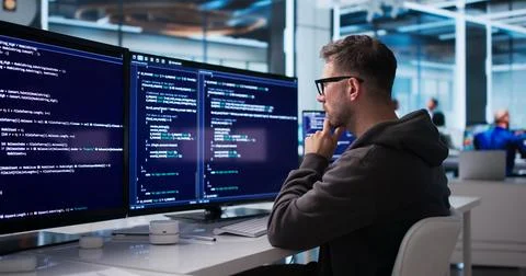 Young Software Engineer Coding Secure Business Platform At Modern Office Desk Stockfoto's