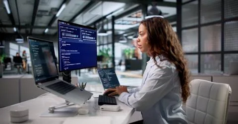 Young Software Engineer Coding Securely On Laptop In Modern Office Workspace  Stock Photos