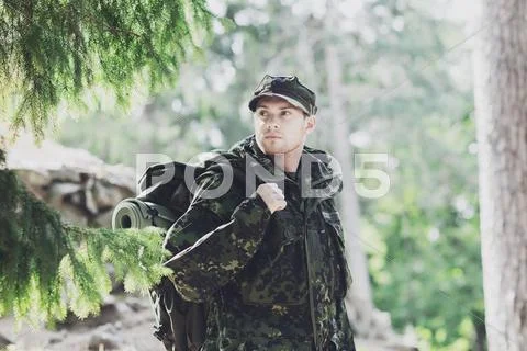 Young soldier with backpack in forest Stock Photos