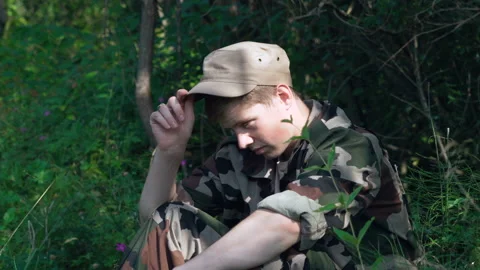 Young soldier sat down to rest in the shade and took off his cap Stock Footage 92041976