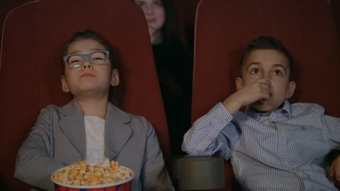 Young spectators watching movie at cinema. Movie children entertainment Stock Footage 93893162