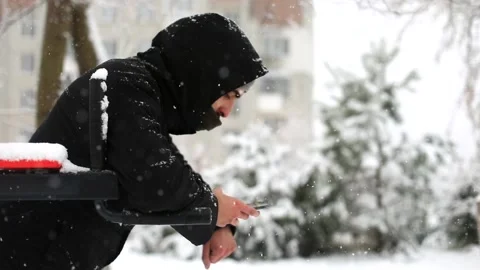Young sport man using smartphone in winter snowfall on sports area outside Vídeos de archivo 166955596