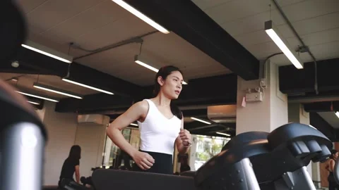 Young sports woman is running treadmill in gym. Doing cardio training	 Stock Footage