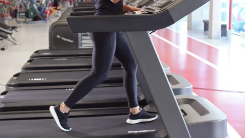 Young Sportswoman using smartphone while jogging on treadmill Stock Footage 88277246