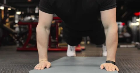 Young sporty man performs push-ups in the gym. The athlete is engaged in fitness Video stock 158760699