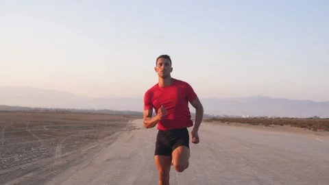 Young sprinter running and doing sports practice on dirt road Video stock 132069919