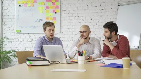 Young startup entrepreneurs discussing problems with their app and brainstorming Stock Footage 94571773