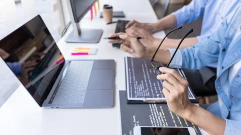 Young startup Programmers Sitting At Desks Working On Computers screen for De 写真素材