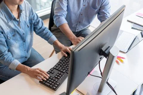 Young startup Programmers Sitting At Desks Working On Computers screen for De Stockfoto's