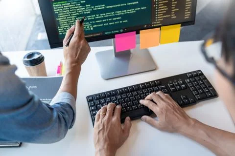 Young startup Programmers Sitting At Desks Working On Computers screen for De Stock Photos