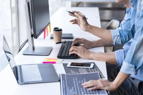 Young startup Programmers Sitting At Desks Working On Computers screen for De Stockfoto's