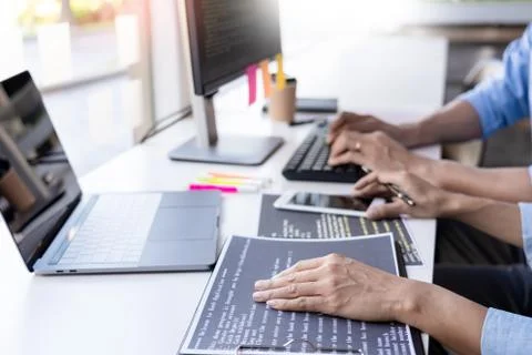 Young startup Programmers Sitting At Desks Working On Computers screen for De Stockfoto's