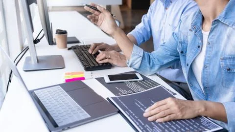 Young startup Programmers Sitting At Desks Working On Computers screen for De Stockfoto's