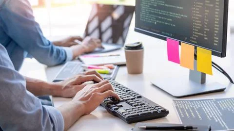 Young startup Programmers Sitting At Desks Working On Computers screen for De 库存照片