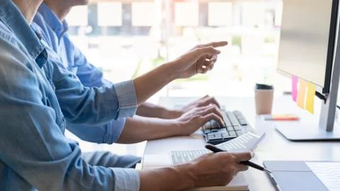 Young startup Programmers Sitting At Desks Working On Computers screen for De Foto stock
