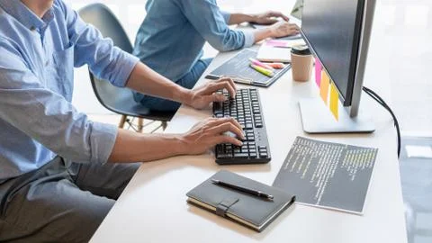 Young startup Programmers Sitting At Desks Working On Computers screen for De 写真素材