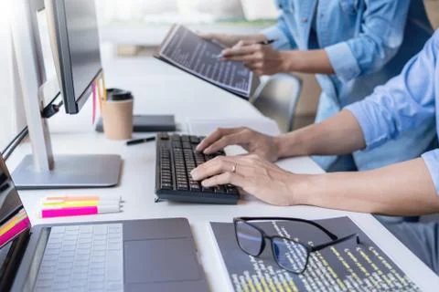 Young startup Programmers Sitting At Desks Working On Computers screen for De 写真素材